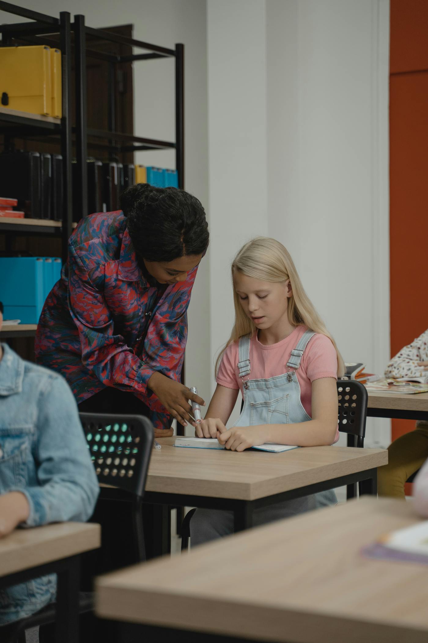 Students and a teacher working together at a classroom table